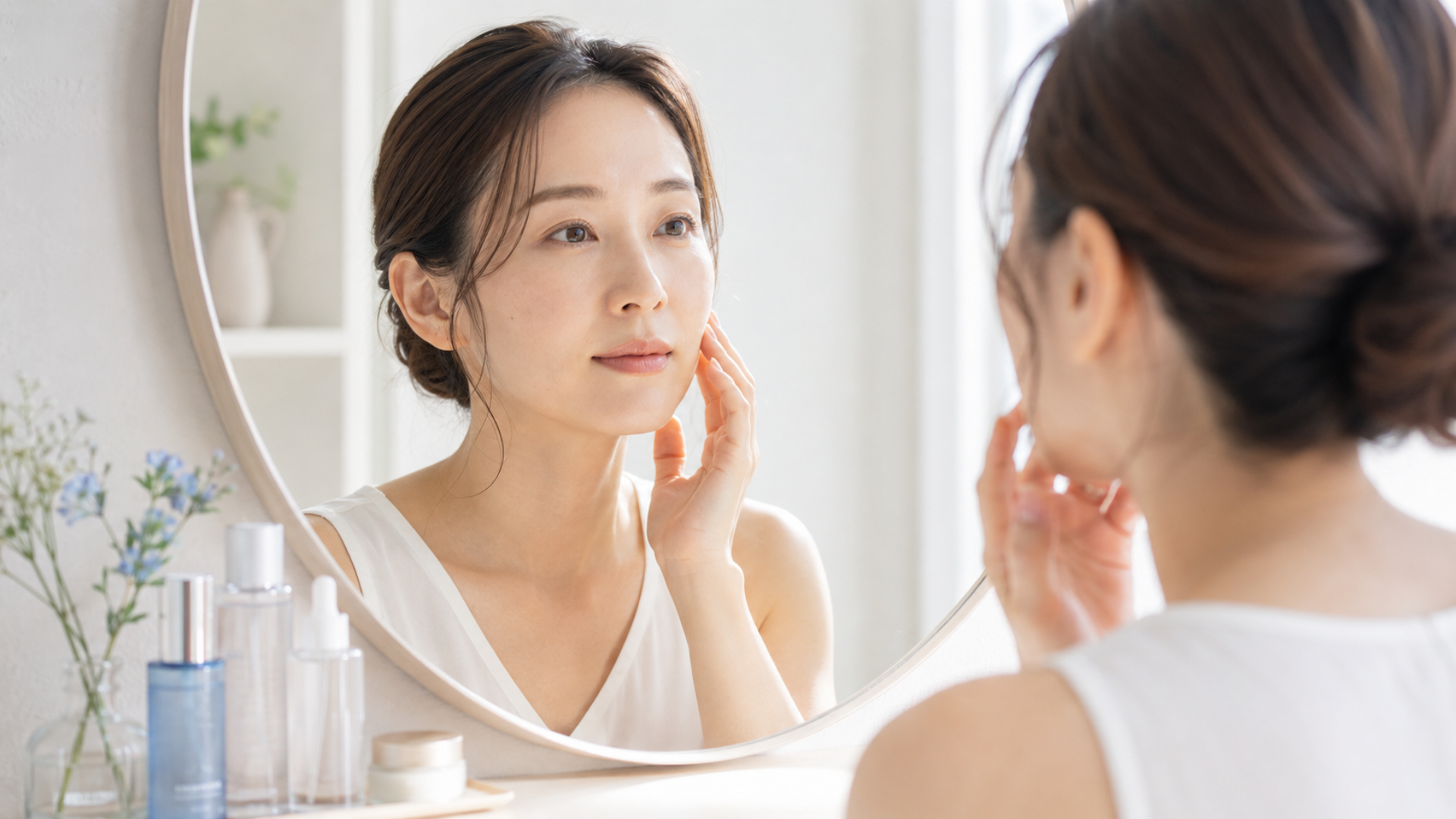 顔のくすみを改善する方法を考えながら鏡で肌を確認する女性
